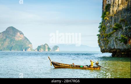 Traditionelles thailändisches Motorboot in der Andamanensee mit Phuket Küste im Hintergrund Stockfoto