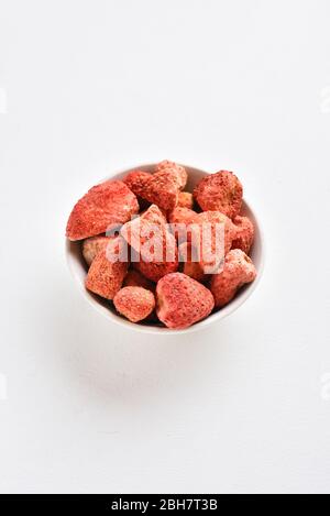 Getrocknete Erdbeeren in Schüssel über weißem Stein Hintergrund mit freiem Text Raum. Stockfoto