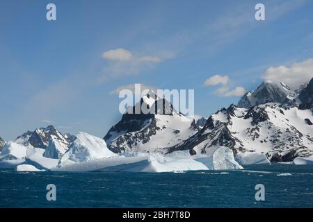 Schwimmende Eisberge vor schneebedeckten Berggipfeln, Drygalski Fjord, Südgeorgien, Südgeorgien und die Sandwichinseln, Antarktis Stockfoto