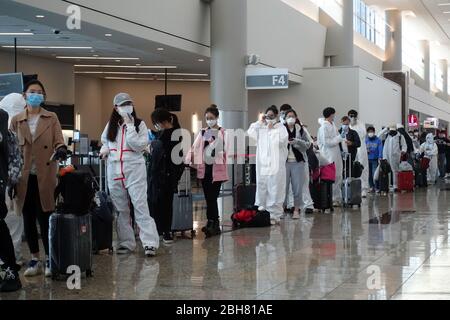 09.04.2020, Atlanta, Georgia, USA - Auswirkungen der Corona-Pandemie: Fluggäste in Schutzanzügen und Atemschutzmasken stehen in einer Schlange Stockfoto