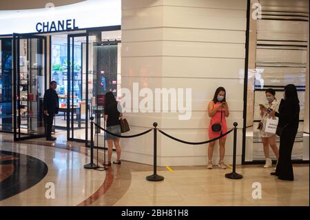 02.04.2020, Singapore, , Singapore - Frauen stehen vor einem Geschäft der Luxusmarke Chanel im Einkaufszentrum Takashimaya und tragen eine Atempause Stockfoto