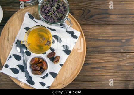 Tee mit Minze im arabischen Stil und Datteln auf Holztisch. Von oben mit viel Platz Stockfoto