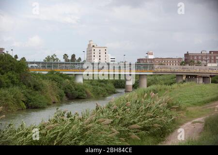 Brownsville, Texas USA, 7. Oktober 2009: Der Rio Grande River, die Grenze zwischen den Vereinigten Staaten und Mexiko, fließt durch die Innenstadt von Brownsville und blickt nach Westen mit Matamoros, Mexiko auf der linken Seite. Die Grenzmauer wird in Abschnitten auf der Seite der Vereinigten Staaten entlang einiger Teile des Flusses errichtet, wo Schmuggel herrscht. © Bob Daemmrich Stockfoto