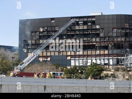 Austin Texas USA, Februar 18 2010: Feuerwehrleiter bringt Feuerwehrmann in die Nähe der Trümmer eines Bürogebäudes, nachdem Joseph Stack III sein einmotorige Privatflugzeug in ein Internal Revenue Service Büro stürzte und sich selbst und einen IRS-Manager im Gebäude tötete. Stack hat Berichten zufolge ein regierungsfeindliches Manifest hinterlassen, in dem seine laufenden Steuerprobleme mit dem IRS detailliert beschrieben wurden. ©Marjorie Kamys Cotera/Daemmrich Photography Stockfoto