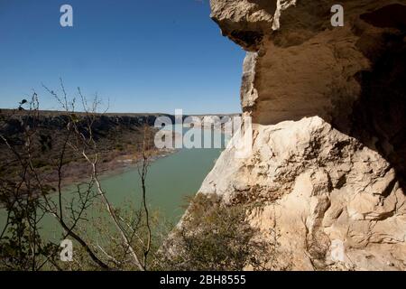 Val Verde County Texas USA, Januar 1 2010: Die zerklüfteten Klippen über dem Rio Grande River, die nach Westen in Richtung Langtry, TX, blicken (mit Mexiko auf der linken Seite), bilden eine natürliche Barriere gegen Schmuggel und Menschenhandel entlang der Grenze zwischen den Vereinigten Staaten und Mexiko. ©Bob Daemmrich Stockfoto