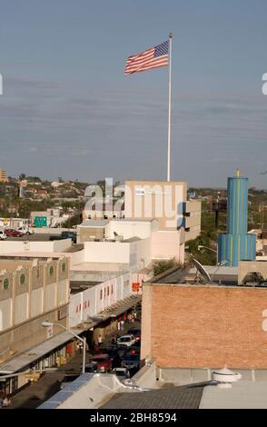 Laredo, Texas USA, 16. Dezember 2009: Die amerikanische Flagge fliegt über der Innenstadt von Laredo, einer Stadt an der Grenze der Vereinigten Staaten zu Mexiko. Die Partnerstadt Nuevo Laredo liegt direkt gegenüber dem Rio Grande. ©Bob Daemmrich Stockfoto