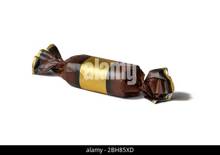 Echte verpackte Schokolade Süßigkeiten auf einem weißen Hintergrund. Eine einzige Süßigkeit in braun mit einer Goldfolie Verpackung. Platz für Text. Isolieren Sie auf weißem Hintergrund. Stockfoto