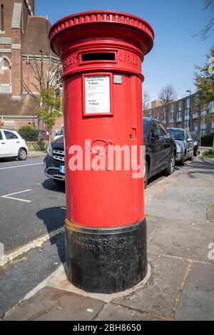 Ikonisches rotes britisches Royal Mail Viktorianisches Postfach mit Königin Victoria VR Victoria Regina Chiffre auf der Vorderseite, in Kentish Town, London Stockfoto