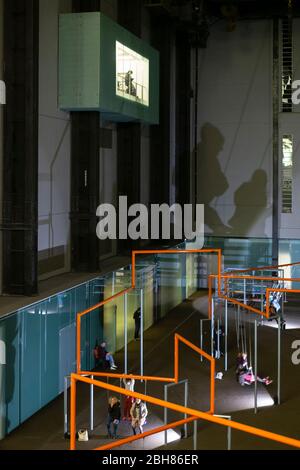 Schatten von Menschen auf Schaukeln werfen auf die Wand bei der Kunstinstallation des dänischen Künstlerkollektivs 'Superflex', Turbine Hall, Tate Modern, London Stockfoto