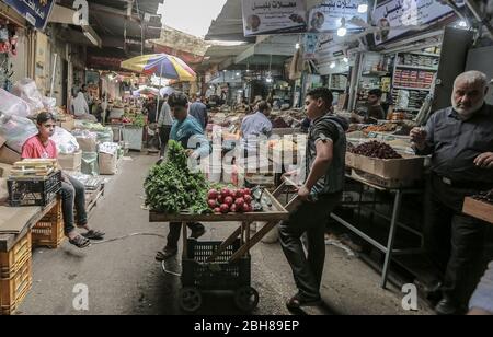 Gaza, Palästinensische Gebiete. April 2020. Palästinenser Muslime kaufen am ersten Tag des heiligen Monats Ramadan auf einem lokalen Markt Lebensmittel und Vorräte ein. Kredit: Mohammed Talatene/dpa/Alamy Live News Stockfoto