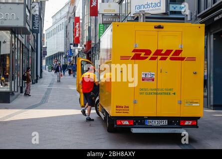 24.04.2020, Essen, Ruhrgebiet, Nordrhein-Westfalen, Deutschland - DHL Paketvan in der Fußgängerzone vor Geschäften, Online und Bahnhof Stockfoto