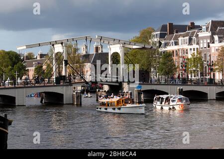 Tour Boote unter der neun-Bogen Holz Skinny Brücke gebaut in 1934, an der Amstel Fluss, Amsterdam Stockfoto