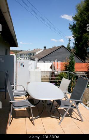 Eine Terrasse mit Edelstahlgeländer und beigefarbenen Bodenfliesen eine Terrasse mit Edelstahlgeländer und beigen Bodenplatten Stockfoto