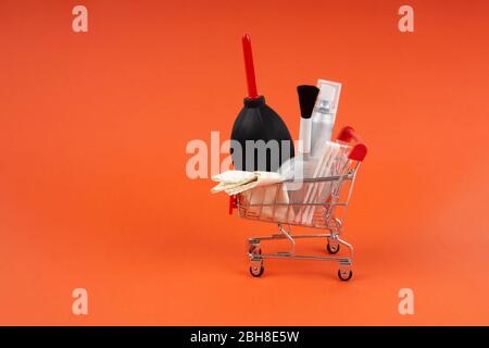 Mini-Warenkorb mit Objektiv und Kamera-Reinigungsset: Staubgebläse, Mikrofaser-Reinigungstuch, Wattestäbchen, Sprühflasche und eine Gebläsebürste. Stockfoto