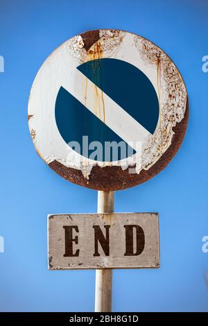 Straßenschild Verbot Zugang, am unteren Rand ein Schild mit dem Wort Ende. Im Hintergrund ein blauer Himmel. Das Straßenschild scheint durch das Wetter beschädigt und r Stockfoto
