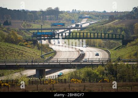 Cumbernauld, Großbritannien. April 2020. Im Bild: Straßenschilder entlang der Autobahn M80, die lauteten: „BLEIB ZUHAUSE, SCHÜTZE NHS, RETTE LEBEN“ die britische Regierung hat eine längere Stillegungen aller großen Städte Großbritanniens angeordnet und die Menschen zu Hause bleiben lassen, obwohl einige Leute die Botschaft der Regierung ignorieren wollen. Bis heute hat die Coronavirus (COVID-19) Pandemie weltweit über 2.74 Millionen Menschen infiziert, und in Großbritannien 143,464 infiziert und 19,506 getötet. Quelle: Colin Fisher/Alamy Live News Stockfoto