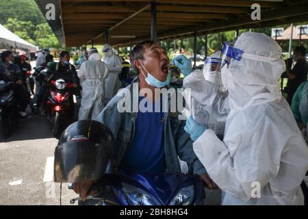 Kuala Lumpur, Malaysia. April 2020. Ein Motorradfahrer (C) hat eine Probe von der Gesundheitshelferin bei einem kostenlosen Coronavirus Community Screening Service in Kuala Lumpur, Malaysia, 23. April 2020 genommen. Länder auf der ganzen Welt ergreifen verstärkt Maßnahmen, um die Ausbreitung des SARS-CoV-2-Coronavirus, das die COVID-19-Krankheit verursacht, einzudämmen. (Foto: Zulfadhli Zaki/Pacific Press) Quelle: Pacific Press Agency/Alamy Live News Stockfoto