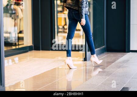 Mode Frau zu Fuß in Stretch Skinny Jeans vor einem Geschäft nach dem Einkaufen Aktivität in der Stadt - Mall Konzept für Dame mit schlanken Beinen und Mode-Stil Stockfoto