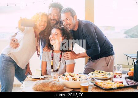 Gruppe von Freunden haben Spaß zusammen bei einem Mittagessen im Freien auf der Terrasse zu Hause und machen ein modernes Selfie mit Smartphone auf Social-Media-Konten für das Internet-Leben zu teilen - Web süchtig glückliche Erwachsene Menschen Stockfoto