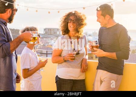 Gruppe von Freunden genießen im Freien mit Bier und Getränken - gemischte Altersgruppen und Generationen kaukasischen Menschen feiern und bleiben zusammen in Freundschaft - sonnige Freizeitaktivitäten Stockfoto