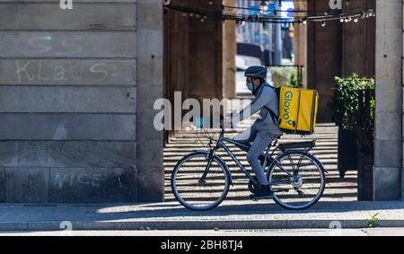 Barcelona, Spanien. April 2020. Glovo Deliveryman, der während des kovidischen Alarmzustands durch die leeren Straßen Barcelonas radelt Stockfoto