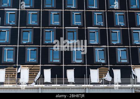 Die freiliegende Verkleidung an der Außenseite eines neuen Gebäudes auf einer Baustelle ohne Arbeiter wurde aufgrund der COVID-19-Sperre eingestellt. Stockfoto