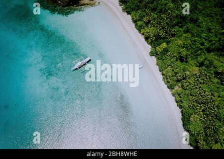 Antenne drone Blick auf die wunderschönen Paradies Lagune und weißen Sandstrand. Lokale Boote auf der Oberfläche. Sommer exotischen Urlaub Konzept. Stockfoto