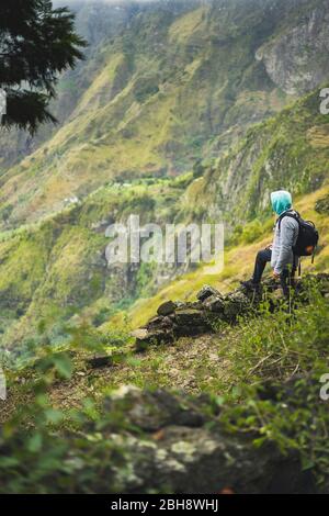 Tourist mit Rucksack Blick über die ländliche Landschaft mit Bergrücken auf dem Weg zum Xo-Xo-Tal. Santo Antao Island, Kap Verde. Stockfoto