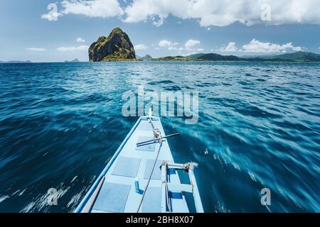 Traditionelle banca Boot Ankunft erstaunliche Pinagbuyatan Insel. Eine kleine kreisförmige Insel mit riesigen Kalksteinfelsen und einem winzigen Ipil-Strand mit Kokospalmen. El Nido, Palawan, Philippinen. Stockfoto