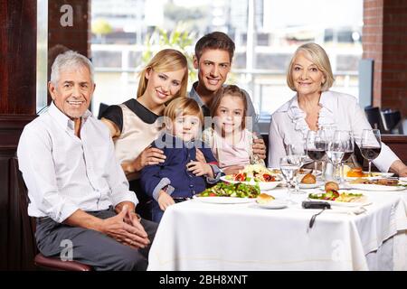 Glückliche Familie der dritten Generation am Tisch des Restaurants Stockfoto