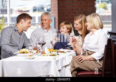 Glückliche Familie, die gemeinsam im Restaurant zu Mittag essen Stockfoto