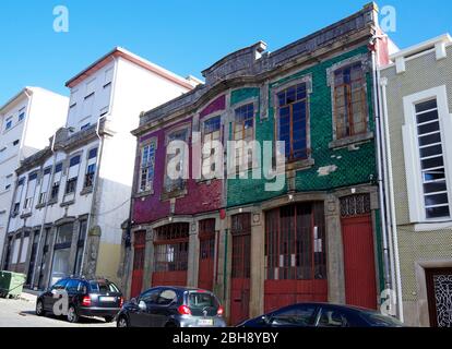 Ein Paar frühe C20-Gebäude mit Werkstätten im Erdgeschoss; Wohnnutzung vorbei, möglicherweise in den frühen Jahren des Motorhandels gebaut, Porto, Portugal Stockfoto