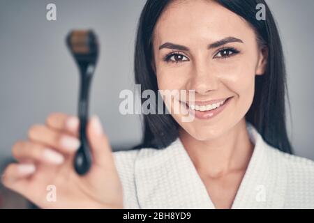 Lächelnd hübsche Frau mit einem Massageroller Stockfoto