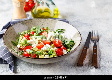 Grüner Salat mit Avocado, Kirschtomaten und Feta-Käse. Gesunde Ernährung Vegetarier Sommer Gemüsesalat. Tischeinstellung, Speisekonzept. Stockfoto