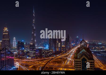 Dubai bei Nacht mit Burj Khalifa und der Zayed Road als wichtigste Straßenkreuzung, gesehen vom Luxushotel Shangri La Stockfoto