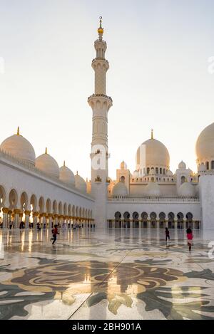 Innenbereich der Scheich Zayid Moschee in Abu Dhabi mit spielenden Kindern bei Sonnenuntergang, Erwachsen ist das Betreten this Bery geboten Stockfoto