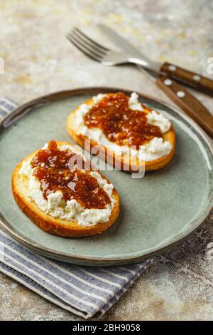 CANape oder Crostini mit geröstetem Baguette, Quark, Feigenmarmelade auf Teller. Köstliche Vorspeise, idealer Aperitif. Stockfoto