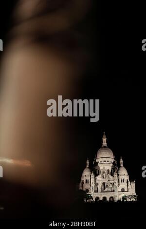 Blick von der Rue de Abbesses auf die Basilika Sacré-Coeur bei Nacht Stockfoto