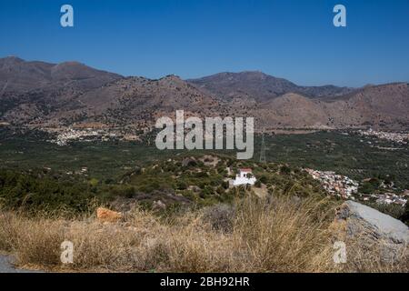 Felsige Berge und Täler mit Olivenbäumen und verschiedenen Vegetation. Sonniger Tag mit blauem Himmel im Herbst. Zentralkreta, Griechenland. Stockfoto