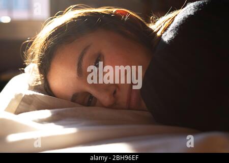 Frau im Bett liegend und lächelnd. Stockfoto