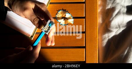Frau schärft ihren Bleistift mit einem Bleistiftspitzer. Stockfoto