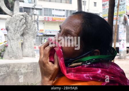 Eine Verwandte aus Bangladesch, die von einem Opfer getötet wurde, das in dem Gebäudeeinsturz des Rana Plaza getötet wurde, reagiert, als sie und andere den siebenjährigen Jahrestag der Katastrophe in T begehen Stockfoto