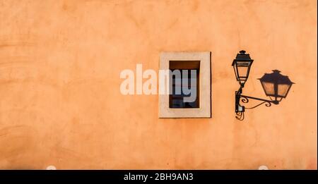 Alte Straßenlampe und Fenster mit Schatten in Coursan Stockfoto