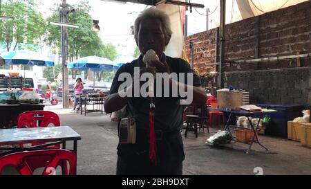 KO CHANG, THAILAND - 9. APRIL 2018: Mann auf einer billigen Restaurantterrasse, der Flöte spielt Stockfoto