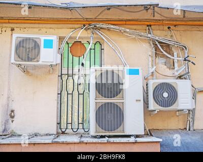 An der Fassade des alten Hauses hängen Klimaanlagen Stockfoto