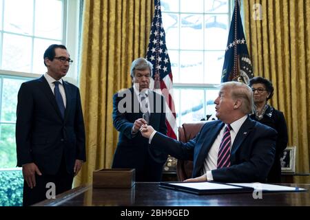 Washington, Usa. April 2020. Präsident Donald Trump überreicht Senator Roy Blunt, R-Mo., einen Stift nach einer Unterzeichnungszeremonie von S.R.266, dem Paycheck Protection Program und Health Care Enhancement Bill, im Oval Office des Weißen Hauses in Washington DC am Freitag, den 24. April 2020. Die Rechnung erweitern Darlehen für kleine Unternehmen und hilft auch medizinischen Mitarbeitern und Tests. Pool Foto von Anna Moneymaker/UPI Credit: UPI/Alamy Live News Stockfoto