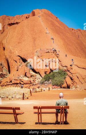 Australien, Ayers, Rock Uluru, Mann auf einer Bank Stockfoto