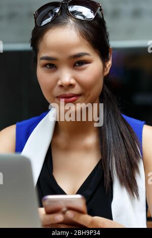 Vietnam lächelnder Student mit Notebook-pc und Handy Stockfoto