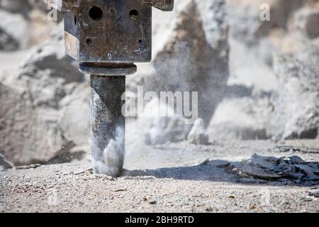 Presslufthammer und Betonbohren, Hämmern für Loch und Stäuben auf Baustelle. Spirituelle Kraft und Penetrationskonzept. Stockfoto