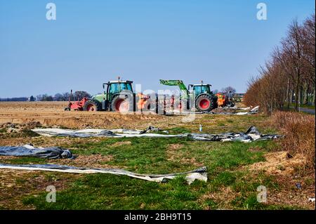 Brandenburg, Deutschland - 28. März 2020: Blick auf Traktoren und Maschinen, die bereit sind, in Deutschland ein Spargelfeld für den Anbau vorzubereiten. Stockfoto